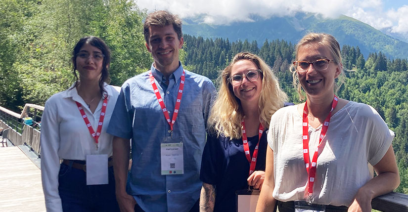 Four people smiling outside.