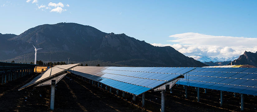 Rows of solar panels with mountains in the background