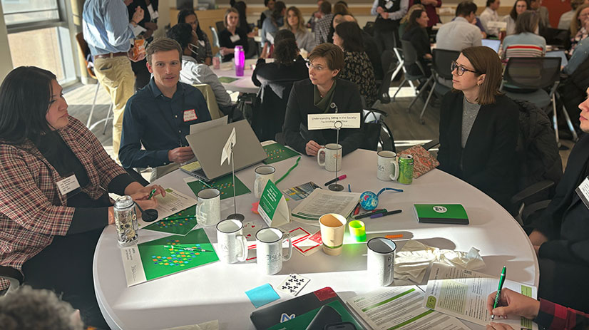 Group of people sit around table having a discussion