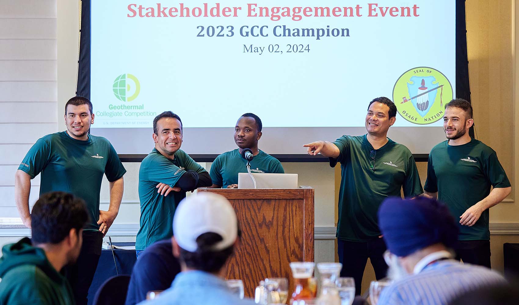 5 students present at a podium.