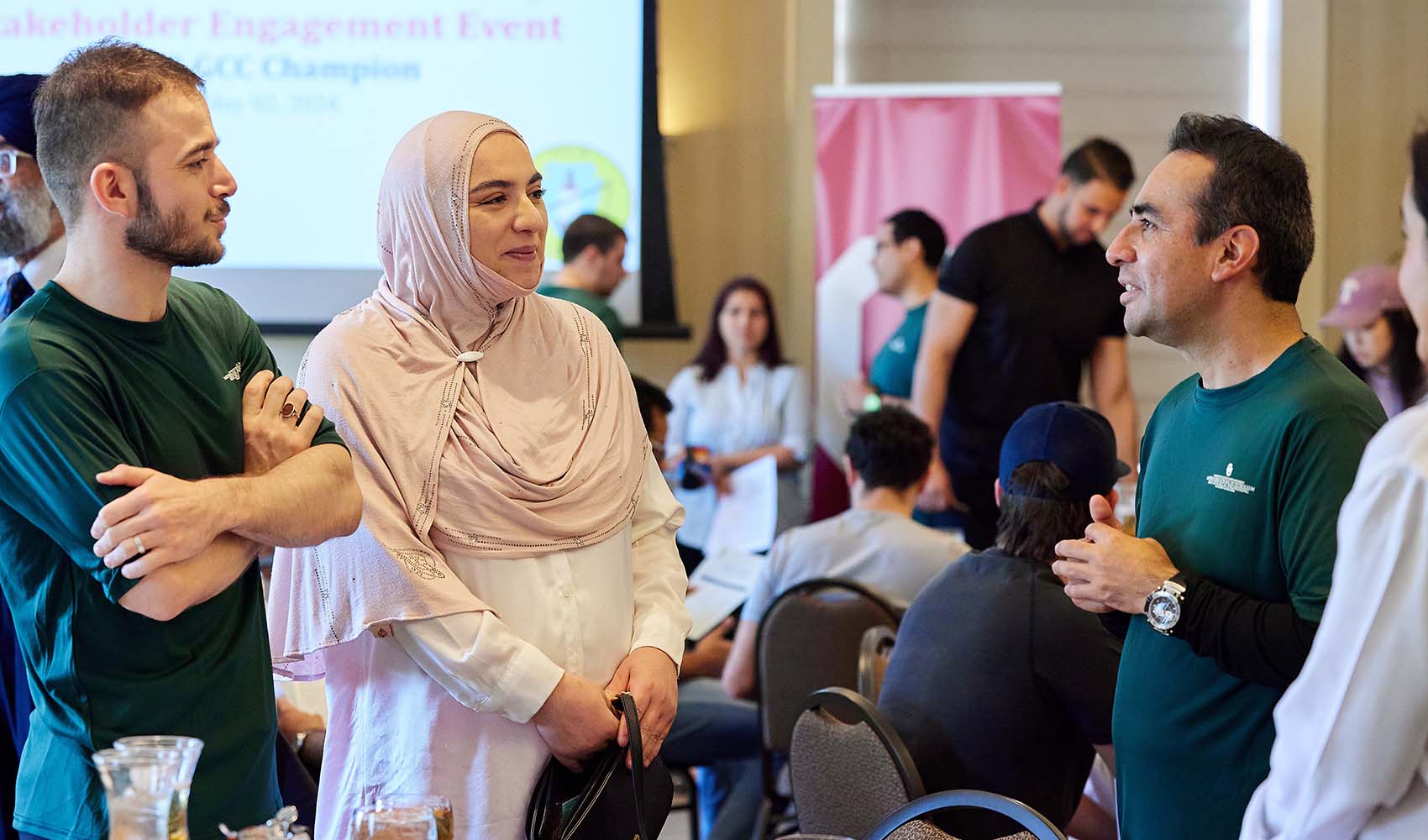 4 people stand while talking at an event.