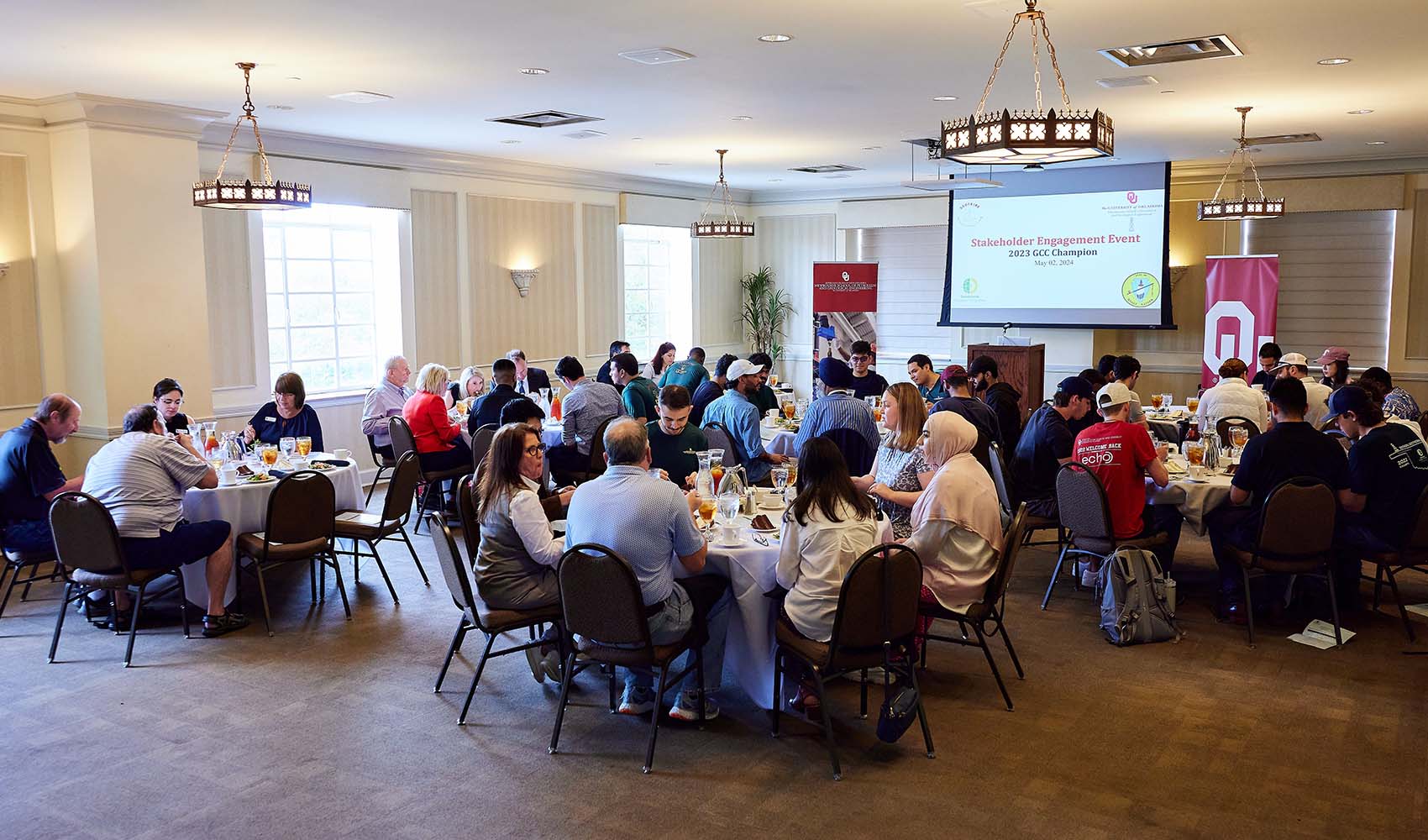 5 circular tables with people having lunch and talking.