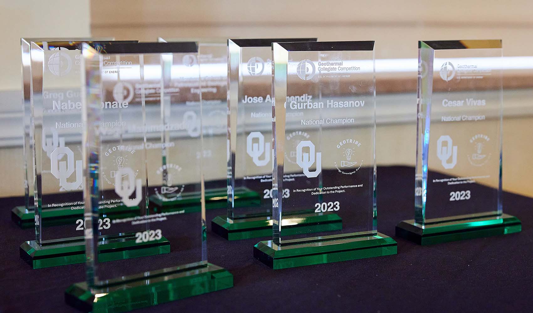 7 glass commemorative plaques sit on a table.