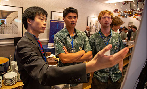 Three students discuss a poster