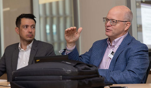 Continue reading about Two people talk at a panel discussion