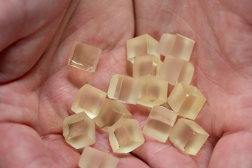 Small cubes of resin in the palm of a hand. 