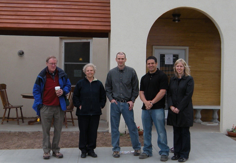 Five people stand in front of a building.