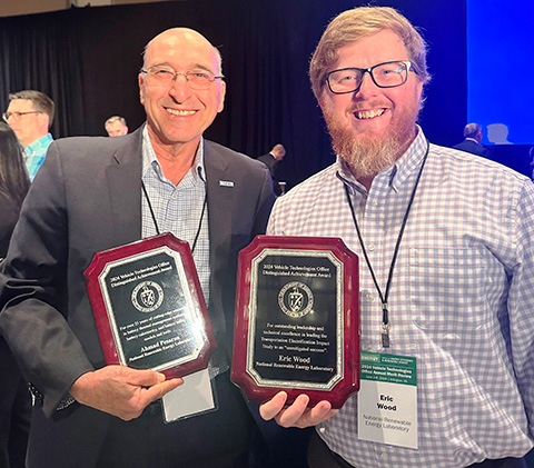 Two men holding awards.