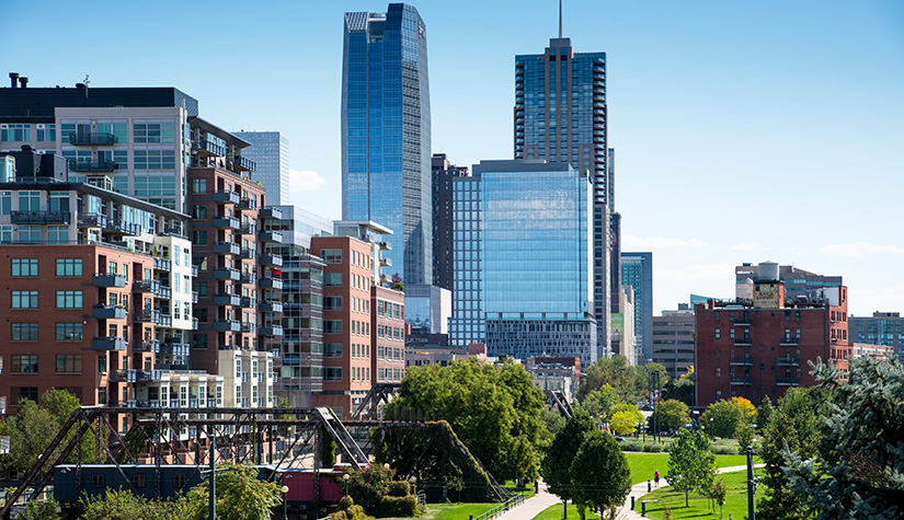 Tall buildings in the background with a lush park in the foreground.