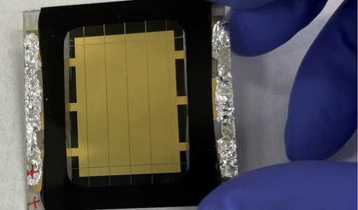 Continue reading about A gloved hand holds a perovskite solar cell.
