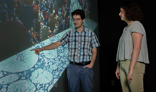 Continue reading about Two people examine images on a screen in a visualization lab.