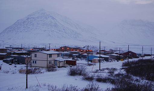 Continue reading about Village of Anaktuvuk Pass, Alaska, in winter, with snow-covered ground, houses, and mountains in the background.