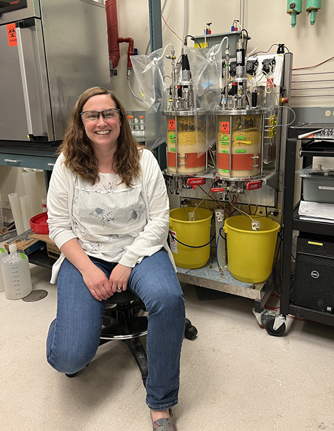 A person sitting in a chair in a lab, smiling.