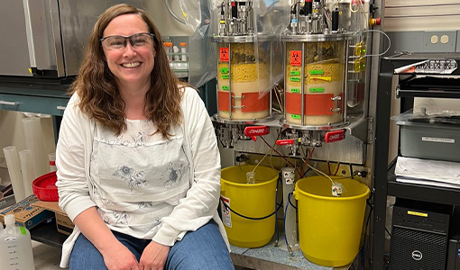 Continue reading about A person sitting in a chair in a lab, smiling.