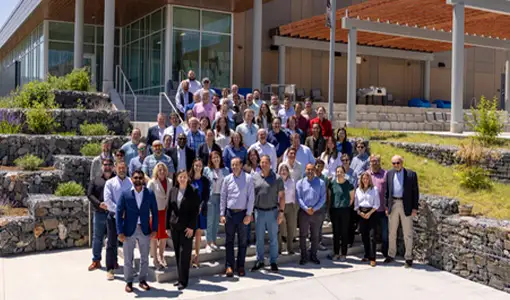 Continue reading about A group of 80 stand outside of a building.