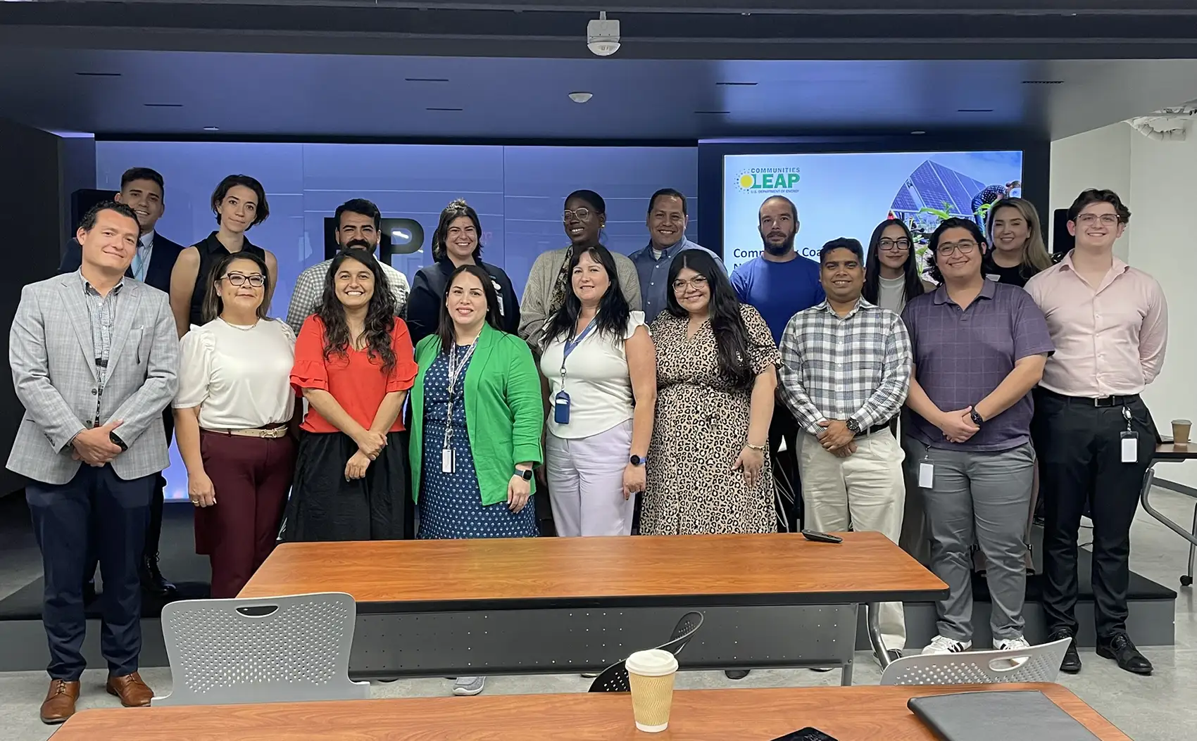Dos filas de personas de pie y sonriendo para una foto grupal