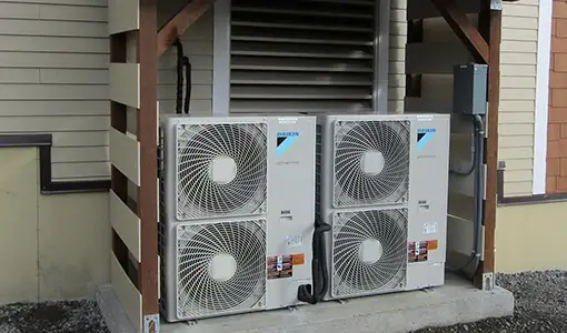 Continue reading about Two air source heat pumps installed on the exterior of a building.