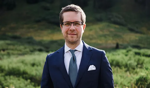 Continue reading about A man wearing a suit standing outside