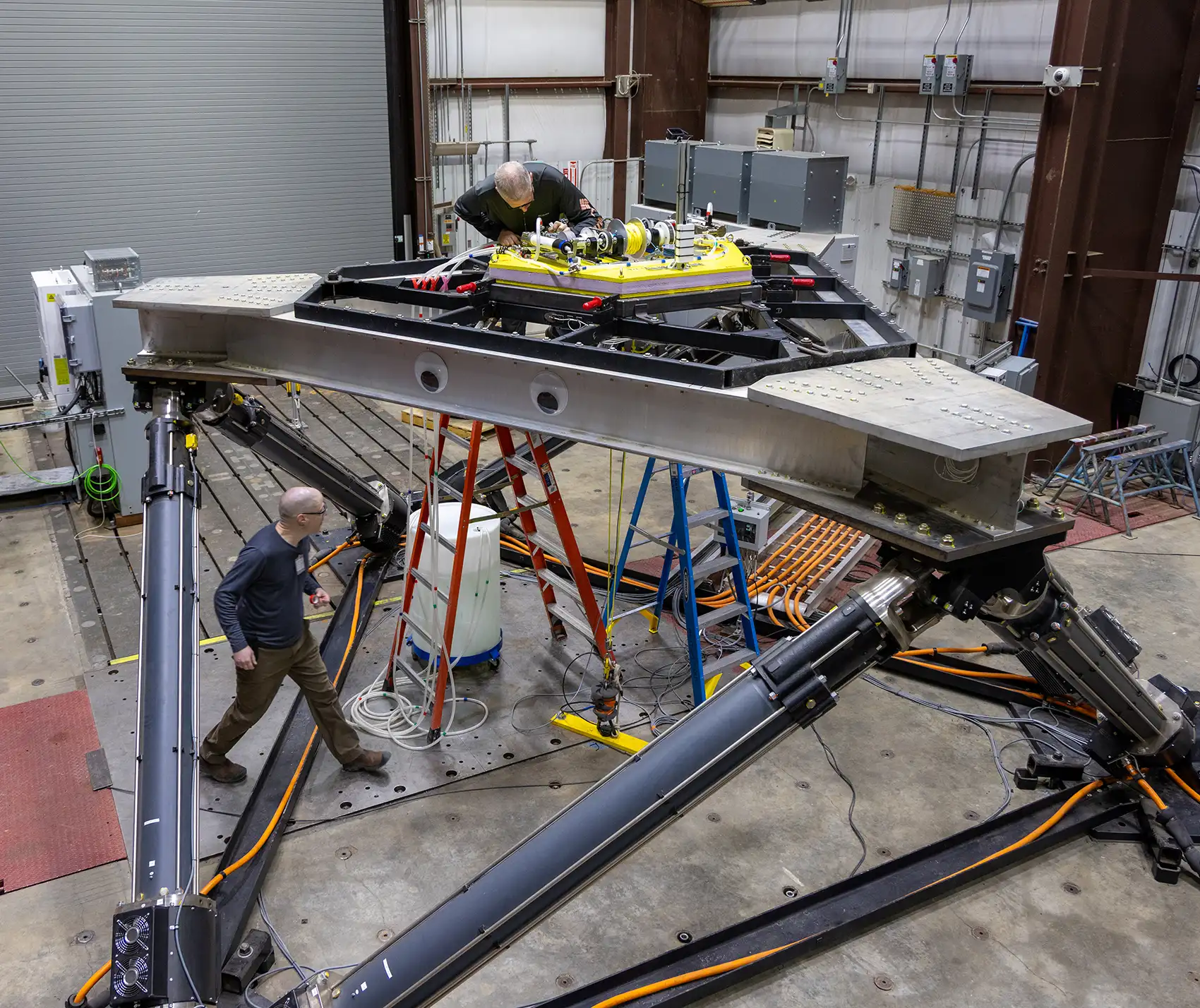 The large-amplitude motion platform with two people working on it.