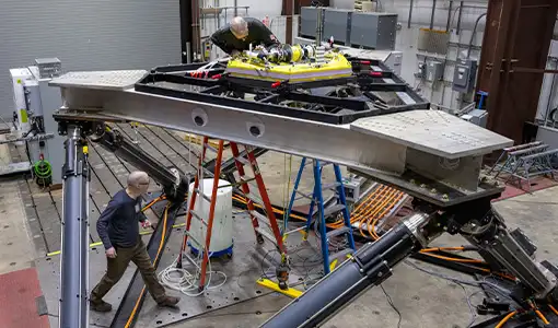 Continue reading about The large-amplitude motion platform with two people working on it.
