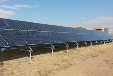 Photo of blue solar panels mounted on the ground.