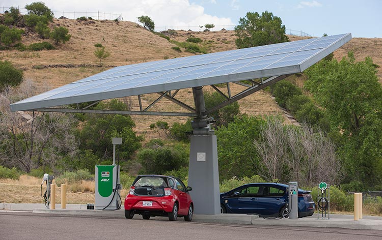 Two electric vehicles parked under a PV canopy.