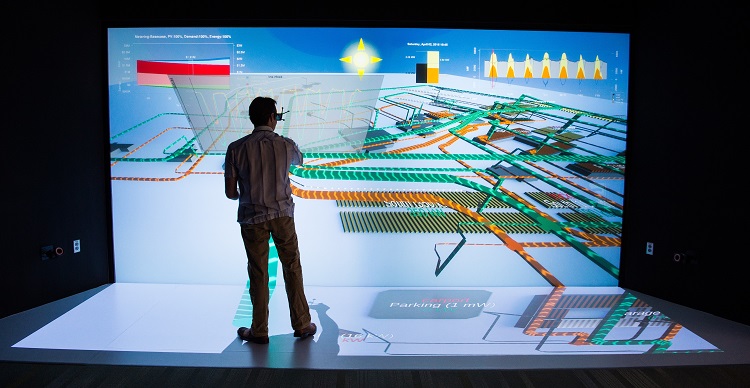 NLR scientist working in front of a wall-sized energy system design schematic in a 3-D visualization laboratory.
