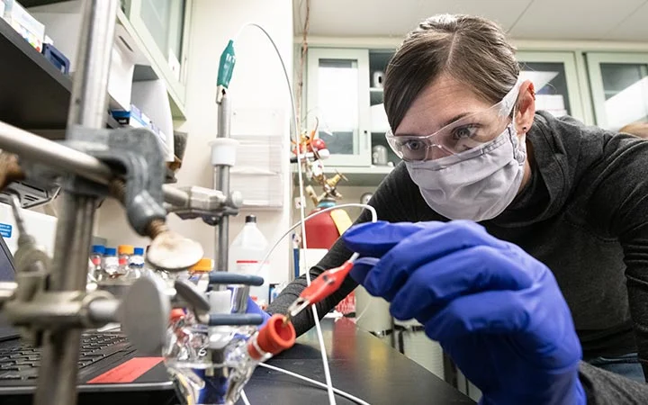 Researcher assembles a 3-electrode electrochemical microcell.