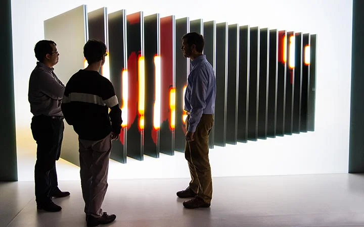 Researchers evaluate simulation stills of a battery in a 3-D visualization room.