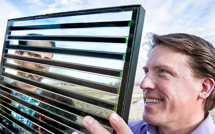 Engineers examine a demonstration model of a Smart Glass product outside.