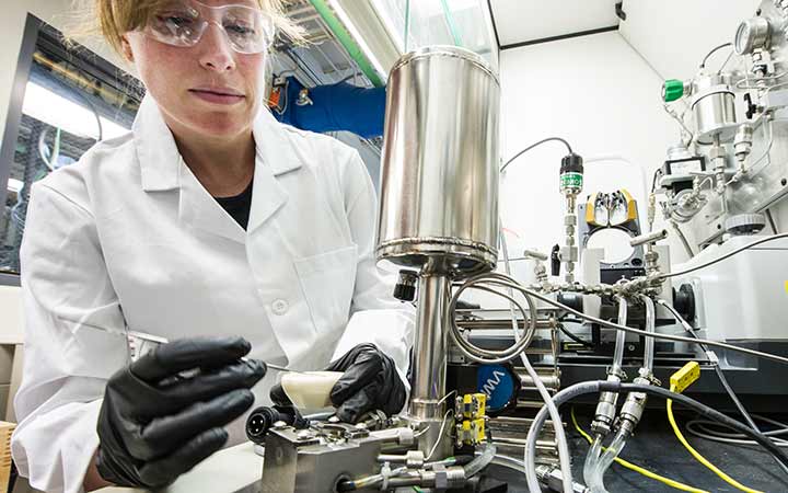 A researcher preparing reactions in a high throughput Parr chromatography system.