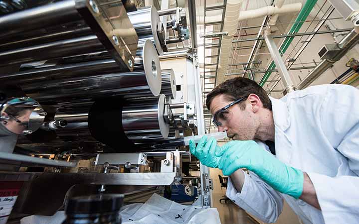 A researcher coats a fuel cell catalyst layer onto carbon-paper diffusion media.