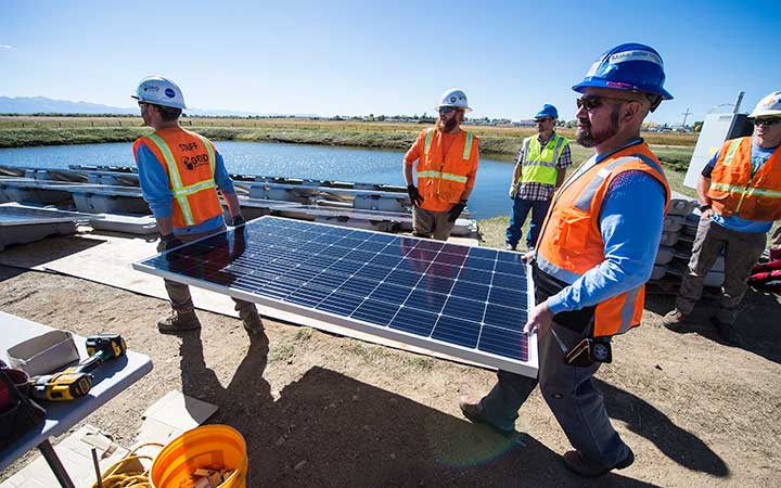 Volunteers assemble and install a floating PV array.