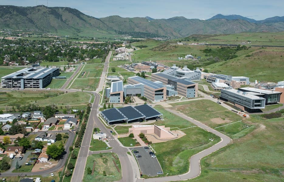 Aerial view of NREL's Golden campus with buildings set against the mountains.