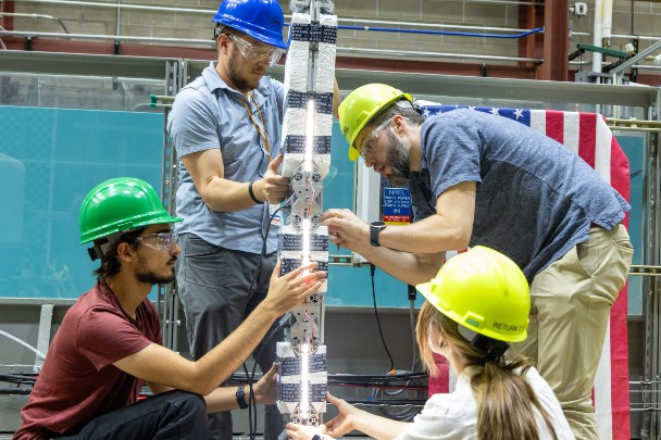 Four people work on hydro kinetic technology device