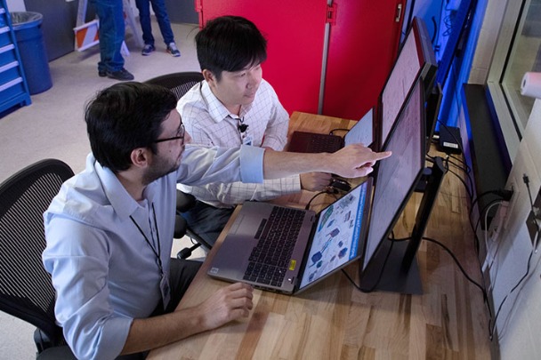 Two people work together on computers