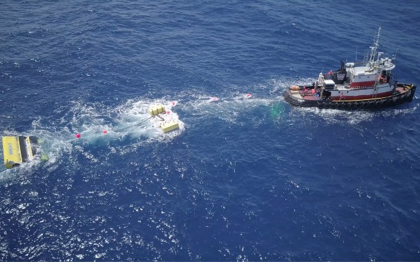 Vessel sails away from marine energy device in ocean
