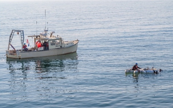 Marine vessel in the ocean next to a small raft