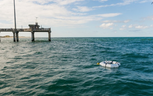Buoy floating in the ocean next to a pier
