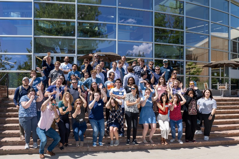 Group of people pose do water poses outside a building