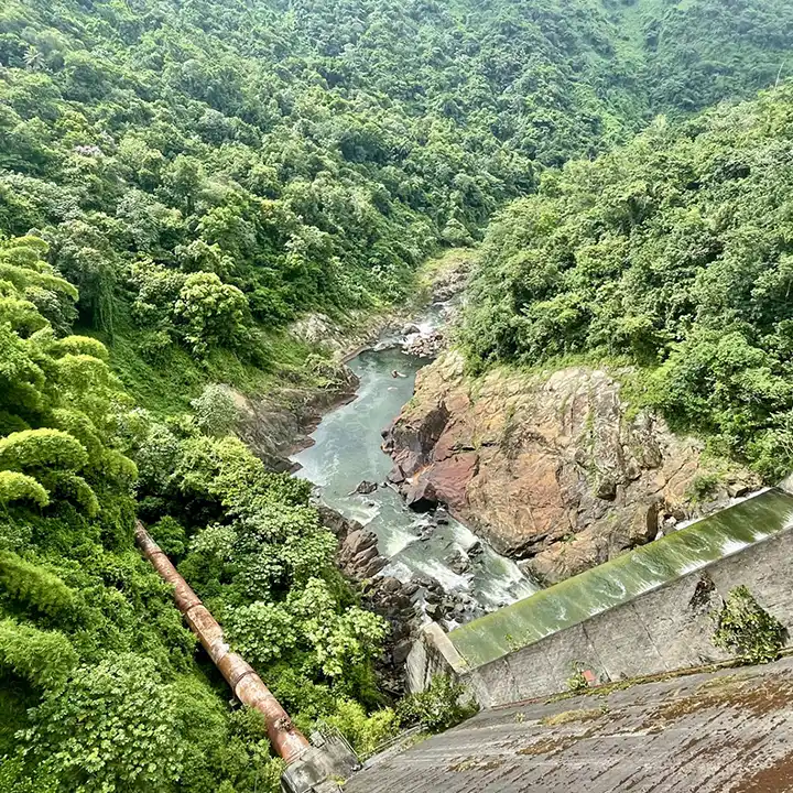 View of dam looking down the side where a river is below