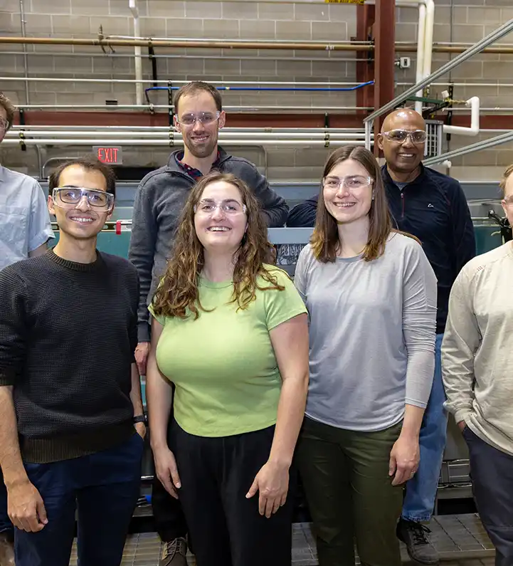 Group of researchers stand in front of the wave tank