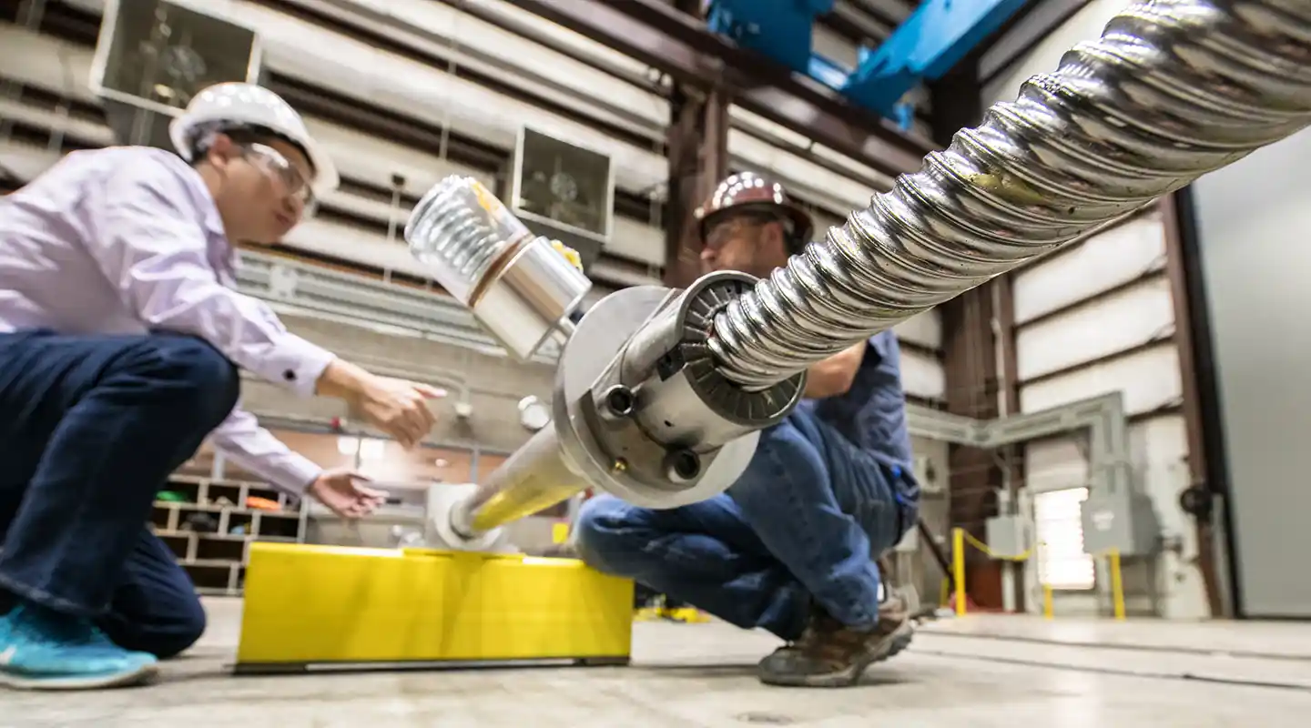 Two researchers in a lab testing a wave energy converter.