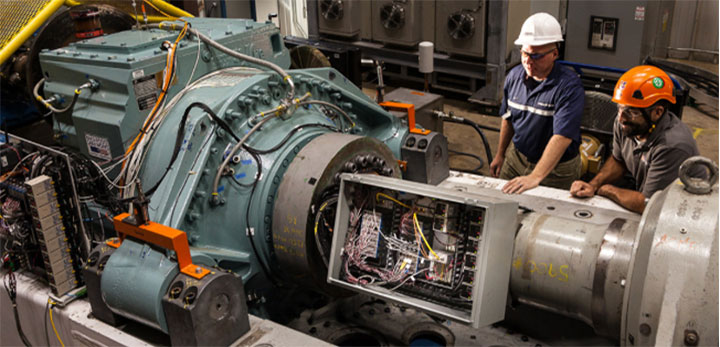 Two people working on marine energy device inside laboratory