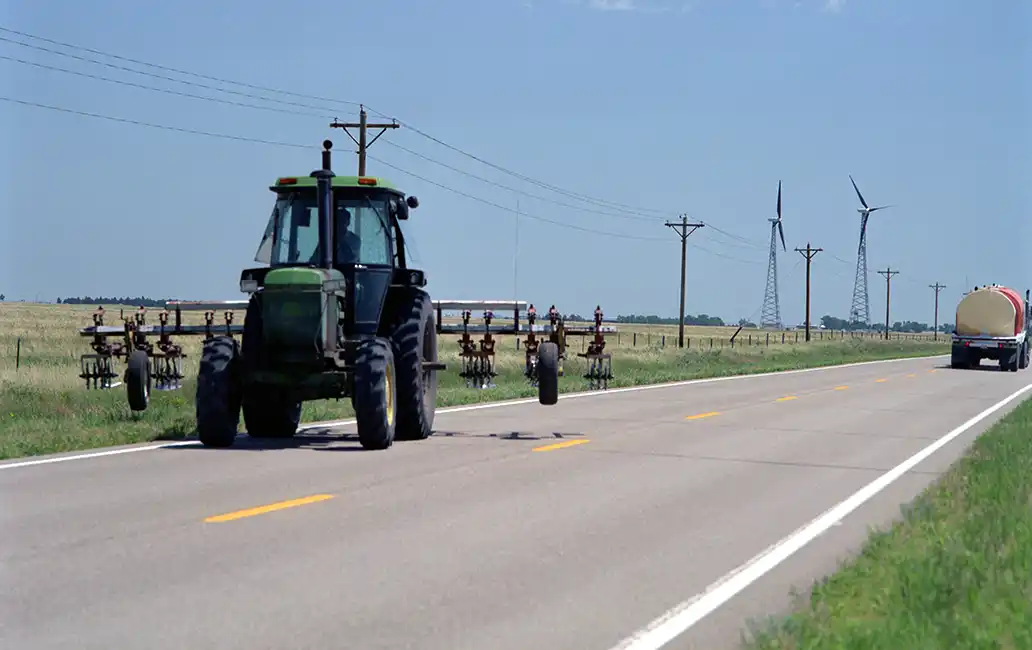 Tractor driving down road.