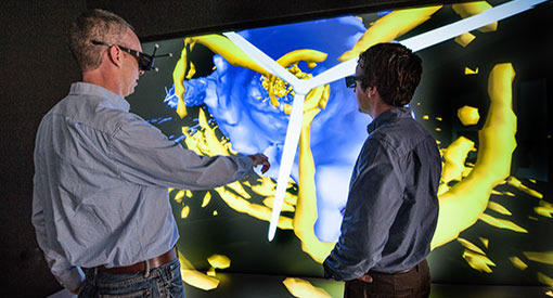 Two people wearing VR headsets looking at wind modeling on screen