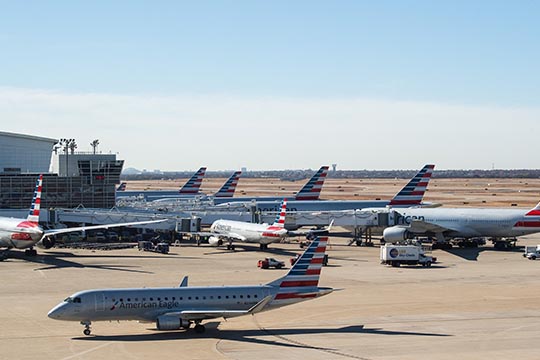 Planes and ground support equipment at an airport terminal.