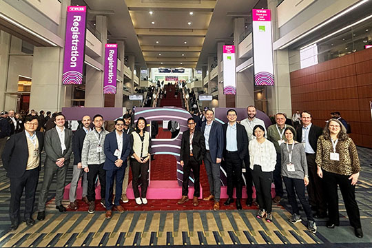 A group of 16 people stand and smile for a photo at the Transportation Research Board conference.