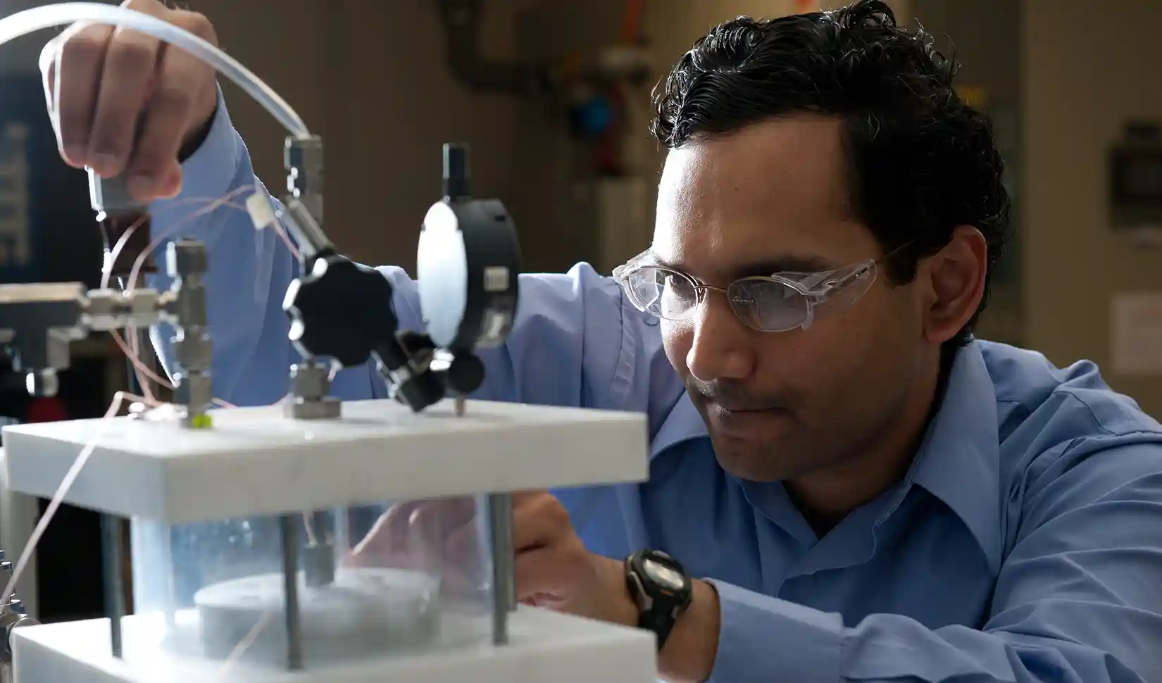 Researcher operating equipment in the Advanced Power Electronics lab.