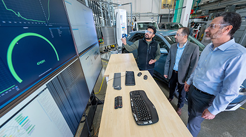 Three researchers looking at computer screens.